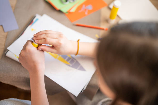 istock Close-up of child's hands creating something with colored paper 1217644365