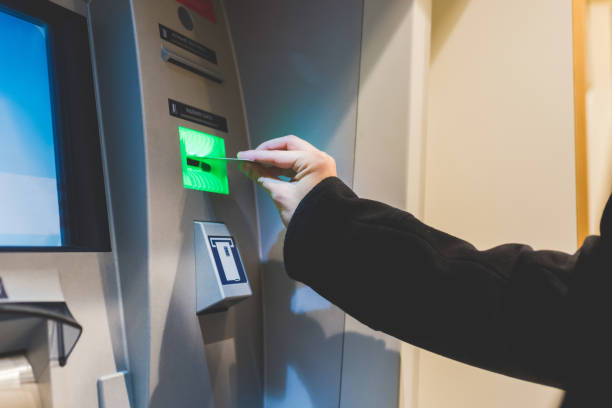 istock Close up on the hand of man inserting debit card in ATM machine 1217645409