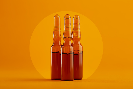 Ampoule. Glass medicine ampoules on orange / yellow background