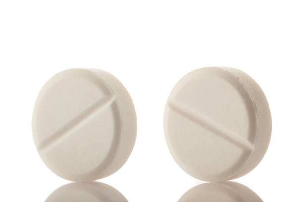 istock White round medical pills on reflective white background 1217646165