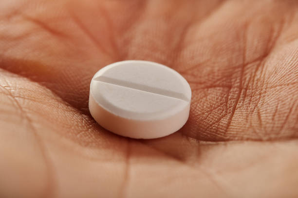 istock White round medical pill in the palm 1217646275