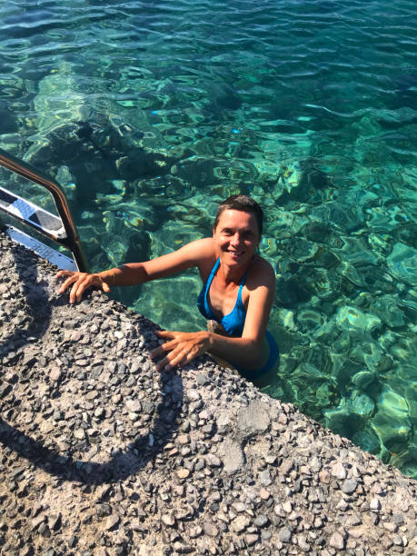 femme heureux avec le bikini regardant l’appareil-photo de la piscine colorée turquoise normale - mobilestock freedom enjoyment blue photos et images de collection