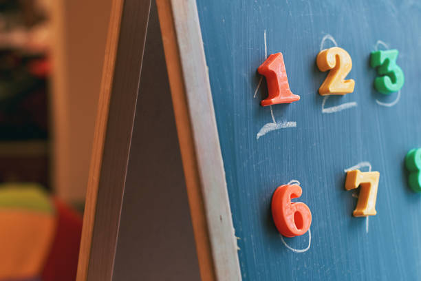 istock Learning numbers on a blackboard with colorful magnets and handwriting on blackboard during homeschooling at quarantine 1217648561
