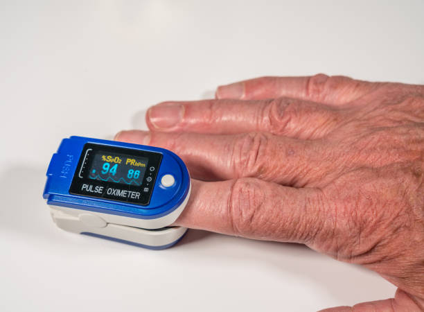 Senior man using a pulse oximeter on finger to test blood oxygen level Pulse oximeter on finger is a good way to test blood oxygen level in case of virus infection of the lungs medical oxygen equipment stock pictures, royalty-free photos & images
