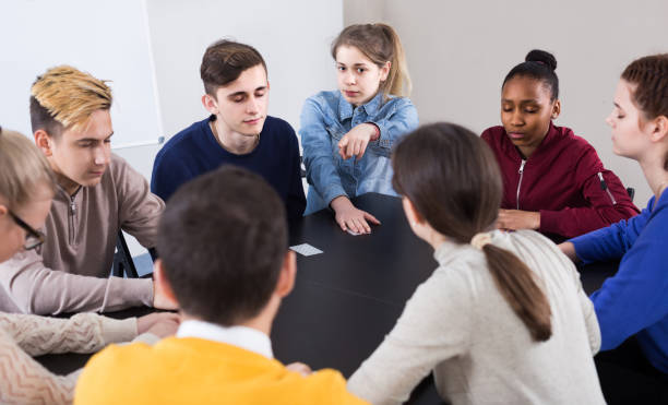 istock Classmates having round of Werewolf game at break between classes 1217649991