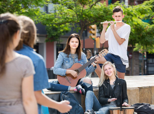 istock Happy friends musicians with instruments in park 1217650578