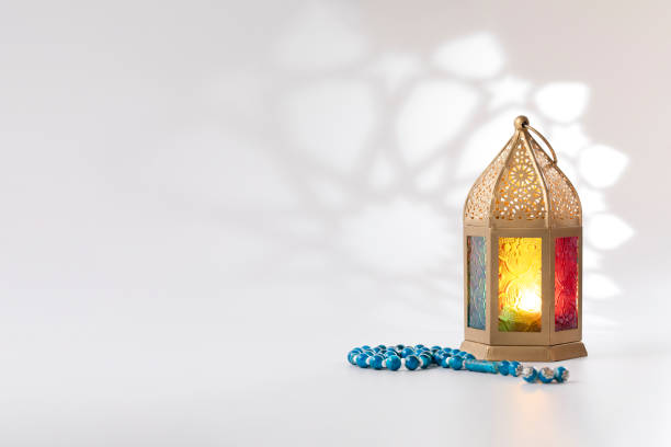 istock Traditional lantern and luxury prayer beads beads on a white background with arabesque shadow effect. 1217651153