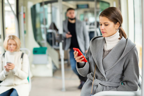 istock Positive woman reading from mobile phone screen in tram 1217651187