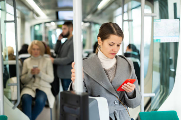 istock Brunette with phone in streetcar 1217651212