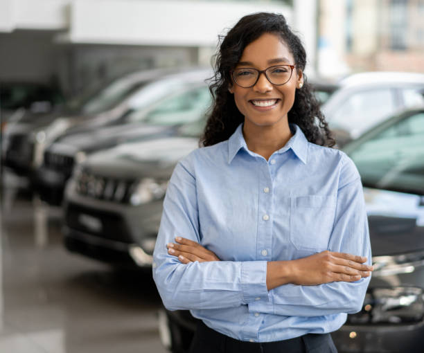 portret szczęśliwej sprzedawczyni pracującej w salonie samochodowym - car african descent shopping car dealership zdjęcia i obrazy z banku zdjęć