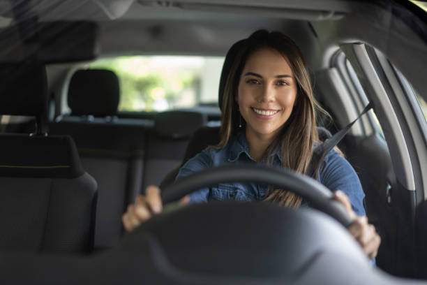 ritratto di una donna che sembra molto felice alla guida di un'auto - woman driver foto e immagini stock