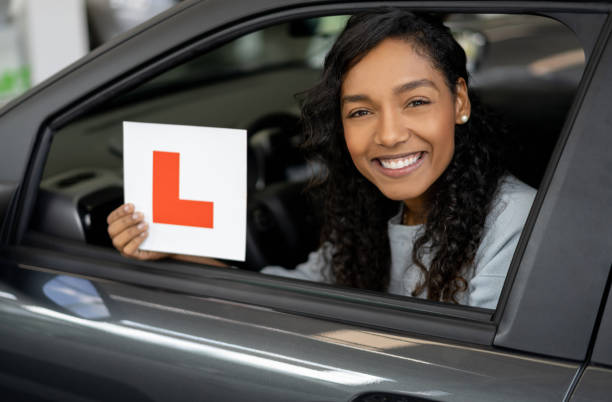 mujer feliz conduciendo un coche usando placas l - l plate fotografías e imágenes de stock