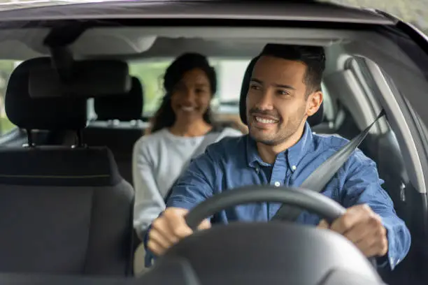 Photo of Happy driver transporting a woman in a car