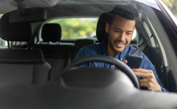 hombre feliz enviando mensajes de texto y conduciendo en su coche - driving text messaging telephone mobile phone fotografías e imágenes de stock