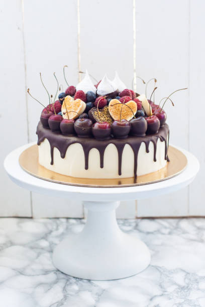 istock Vanilla cheesecake decorated with melted dark chocolate, fresh berries, cherries, chocolate hearts and meringues. 1217653771