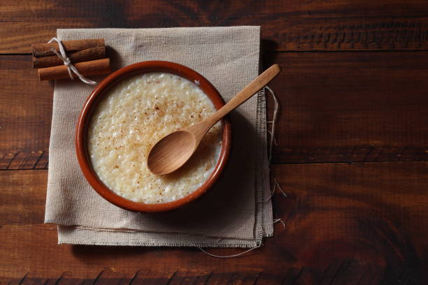 budino di riso con un pizzico di cannella e limone, su uno sfondo di legno invecchiato - rice pudding foto e immagini stock