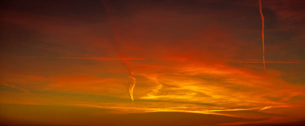 istock Stripes from plane in red bright summer sunset sky 1217656424
