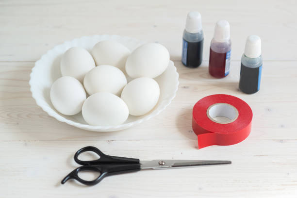 preparação para coloração de ovos para o feriado de páscoa chrestian com o uso de fita adesiva. ovos, tesouras, fita adesiva e corante alimentar - paint preparation adhesive tape indoors - fotografias e filmes do acervo