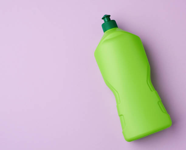 istock green plastic bottle with detergent, purple background 1217661806