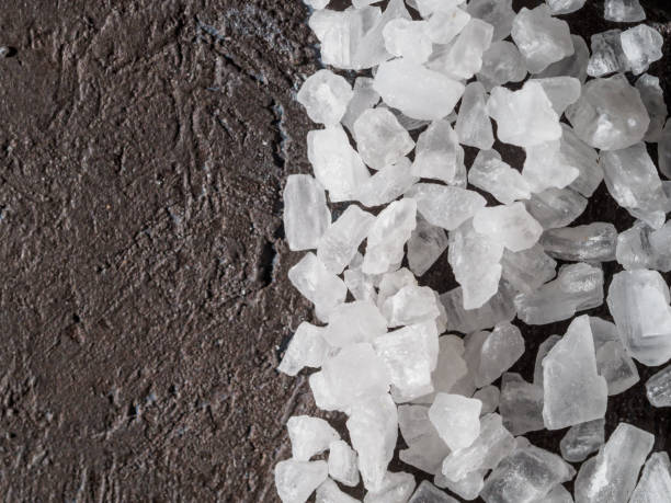istock Crystals of sea salt on dark background. 1217663457