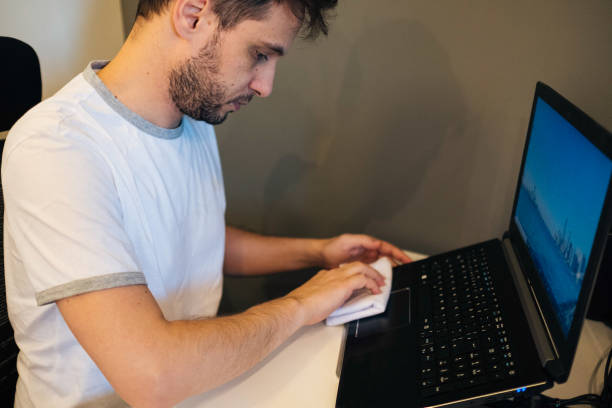 istock Man Cleaning Laptop 1217664817