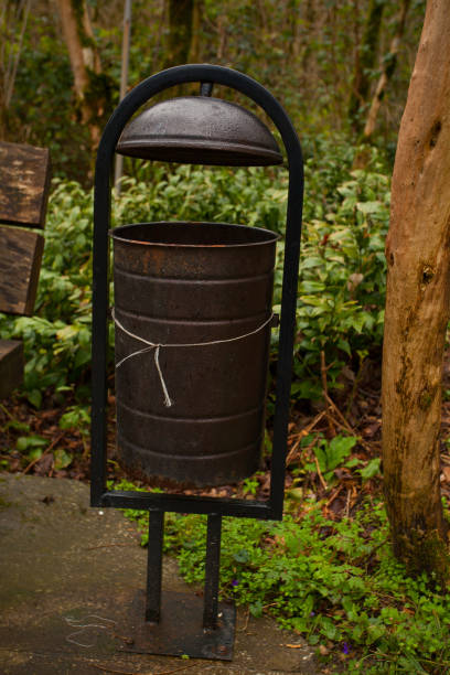 istock Black garbage bin in the forest on green background in a recreation area 1217665194
