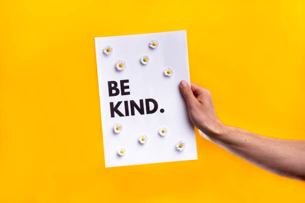 istock Hand held sign for World Kindness Day on yellow studio background 1217667439