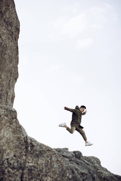 istock A young hipster man is jumping off a cliff 1217667611