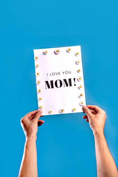 istock Hand held sign for Mother's Day on light blue studio background 1217667621