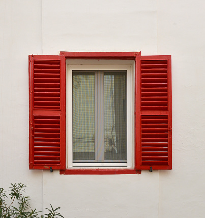 Window with shutters on the wall of the house
