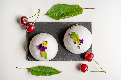 High Angle View of Homemade Dome Desert Served on Stone Plate Decorated with Cherries and Leaves