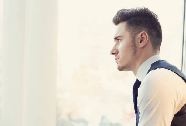 istock Serious man looking away in window 1217672818