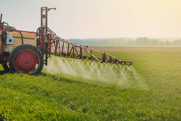 trattore che spruzza erbicidi sull'agricoltura di campo - spraying agriculture farm herbicide foto e immagini stock