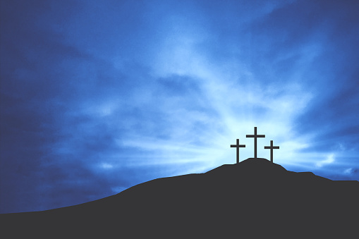 Three Christian Easter Crosses on Hill of Calvary with Blue Clouds in Sky and Copy Space - Crucifixion of Jesus Christ