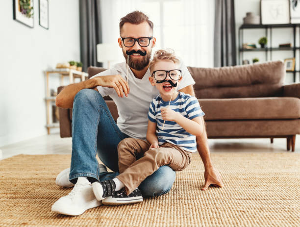istock Father and son having fun with mustache at home 1217680317