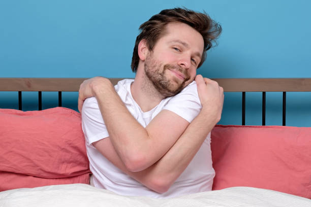 istock Mature caucasian man hugging himself with opened eyes at bed alone. 1217681284