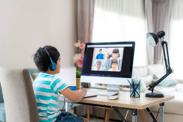 istock Asian boy student video conference e-learning with teacher and classmates on computer in living room at home. Homeschooling and distance learning ,online ,education and internet. 1217682389