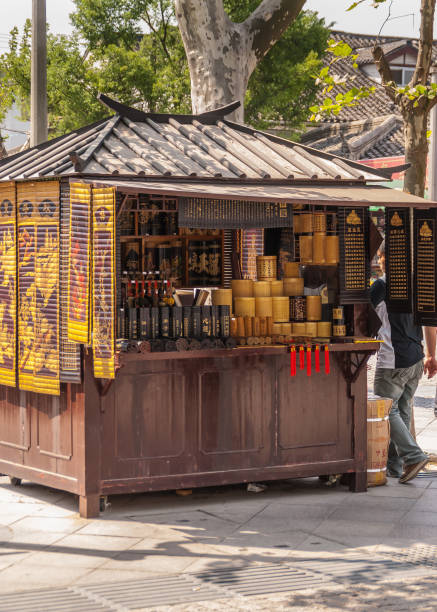 Tea booth on street, Suzhou, China. Suzhou China - May 3, 2010: Brown and yellow tea booth in middle of shopping street under green foliage tree. lake tai stock pictures, royalty-free photos & images