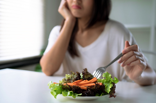 Las mujeres infelices están en el tiempo de dieta, chica no quieren comer verduras. photo