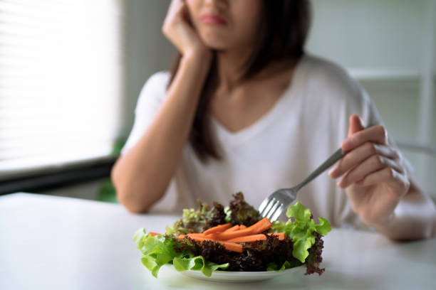 mulheres infelizes estão em tempo de dieta, menina não quer comer vegetais. - esfomeado - fotografias e filmes do acervo