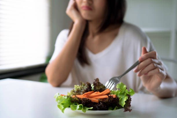 несчастные женщины на диете время, девушка не хочет есть овощи. - поражение стоковые фото и изображения