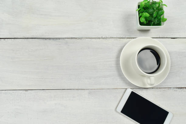 istock Coffee and smartphone on white wooden table background. 1217688400