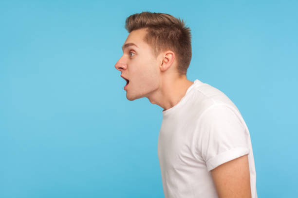 Wow Amazing Side View Of Astonished Man In Casual White Tshirt Standing  With Mouth Open In Surprise Stock Photo - Download Image Now - iStock