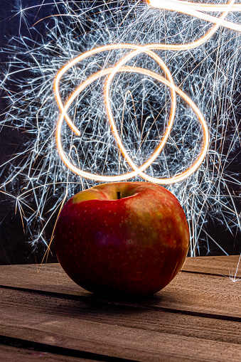 Light painting over an apple with a hand-held sparkler.
