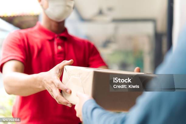 Asian Postman Deliveryman Wearing Mask Carry Small Box Deliver To Customer In Front Of Door At Home Man Wearing Mask Prevent Covid19 Corana Virus Affection Outbreak Social Distancing Work Concept Stock Photo - Download Image Now