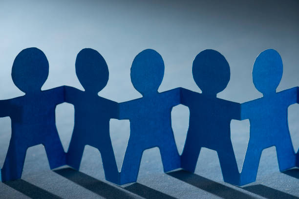 istock Paper dolls holding hands symbolizing union and team 1217705065