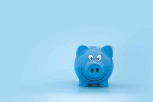 istock Ceramic cute blue piggy bank with copy space on blue background 1217705157