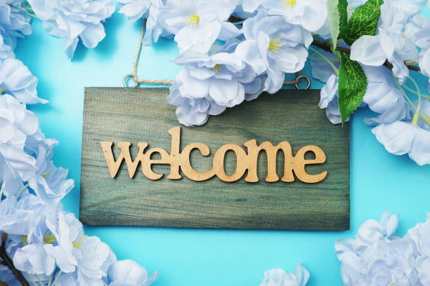 istock Welcome Sign and Flower Blooming Decoration on blue background 1217706864