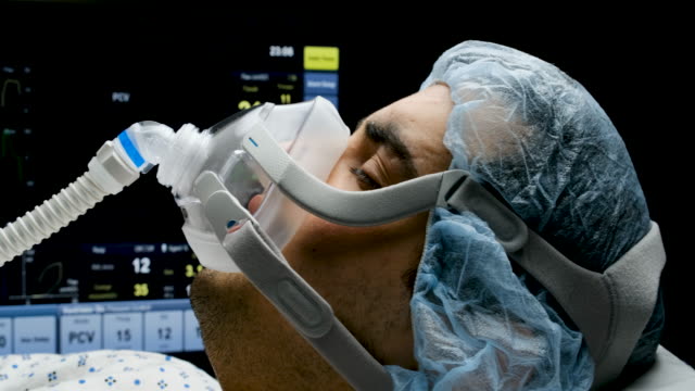 Young man connected to a ventilator mask