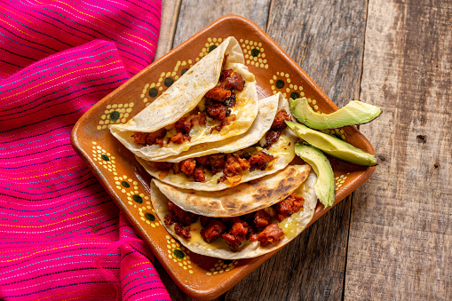 Traditional mexican quesadillas with chorizo on wooden background